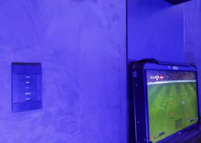 The image shows a crestron horizon light switch on a suade wall in a luxury gaming room in Cheshire