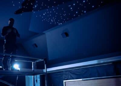 Installer working on the fibre-optic star ceiling during the Wynyard Park home cinema construction